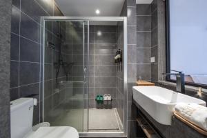 a bathroom with a shower and a sink and a toilet at JIDMI HOTEL in Xiamen