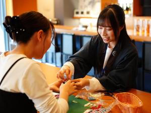 two women sitting at a table working on a project at HOTEL SUI HAMAMATSU by ABEST in Hamamatsu
