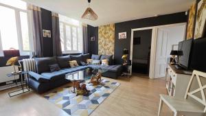 a living room with a blue couch and a glass table at Domaine Les Tourelles - Gîte 3 in Caffiers