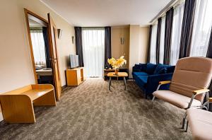 a living room with a blue couch and chairs at Sapphire Hotel Rooms Lechicka in Poznań +126 photos