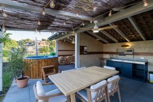 an outdoor kitchen with a wooden table and chairs at Un Occhio Sul Lago in Dormelletto