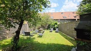 a backyard with chairs and a table and a fence at Domaine Les Tourelles - Gîte 3 in Caffiers
