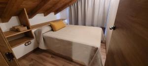 a small bedroom with a bed with a yellow pillow at A Bodega da Xesteira in Melón