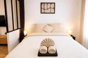 a pair of slippers sitting on a bed at La Suite Prestige in Château-Thierry