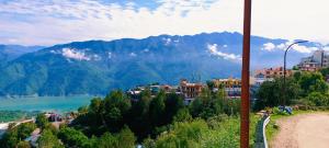 a view of a city with a lake and mountains at Hotel Bhagirathi in Tehri-Garhwāl