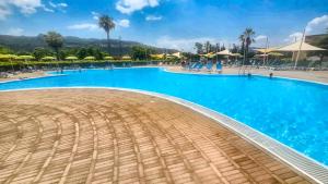 a large swimming pool with blue water at Casa Onde Chiare - Pizzo Beach Club 16G in Fondaco Vecchio +24 photos