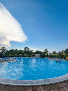 a large blue swimming pool with people in it at Casa Onde Chiare - Pizzo Beach Club 16G in Fondaco Vecchio