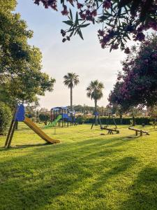 a park with playground equipment and palm trees at Casa Onde Chiare - Pizzo Beach Club 16G in Fondaco Vecchio