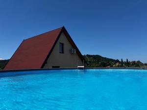 a large swimming pool with a building in the background at Kuća Sunny Rudnik in Rudnik