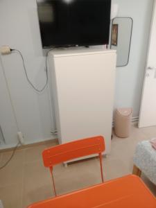 a red bench and a tv in a room at Christos in Asvestokhórion