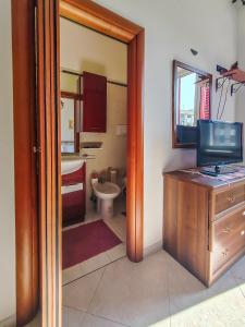 a bathroom with a toilet and a television on a desk at Casa Arcobaleno in Conversano +30 photos