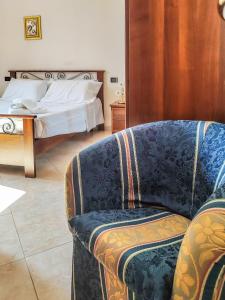 a bedroom with a bed and a couch and a chair at Casa Arcobaleno in Conversano