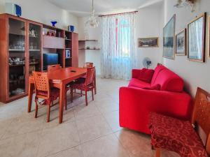 a living room with a red couch and a table at Casa Arcobaleno in Conversano