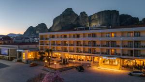 a large hotel with a mountain in the background at Divani Meteora Hotel in Kalabaka