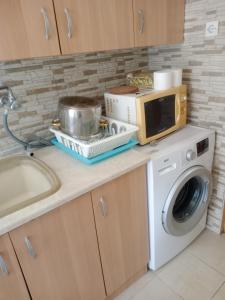 a kitchen with a washing machine and a microwave at Christos in Asvestokhórion