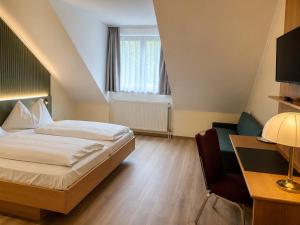 a bedroom with a bed and a desk and a chair at Waldviertler-Hof in Langschlag
