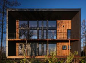 a modern house with glass windows at Adagio Retreat Tokachidake in Biei