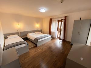 two beds in a room with wooden floors at Pensiunea Barsan in Vişeu de Sus