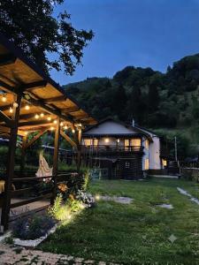 a pavilion with lights in a yard at night at Pensiunea Barsan in Vişeu de Sus