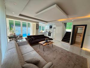 a living room with a couch and a table at Luxury villa in mountain in Geyikbayırı