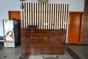 a wooden counter in a room with a soda machine at Hotel Ram Way in Visakhapatnam