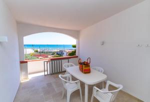 a dining room with a table and chairs and a view of the ocean at Village La Canzone del Mare in Vieste