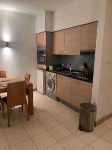 a kitchen with a table and a sink and a washing machine at Vila Verde in Palha Verde