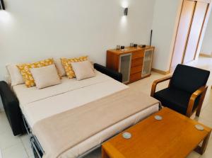 a bedroom with a bed and a chair and a table at Vila Verde in Palha Verde