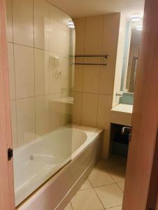 a white bath tub in a bathroom with a mirror at Vila Verde in Palha Verde