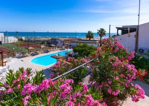a resort with a swimming pool and pink flowers at Village La Canzone del Mare in Vieste