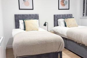 two beds sitting next to each other in a bedroom at The Apollo Apartments in Saint Neots