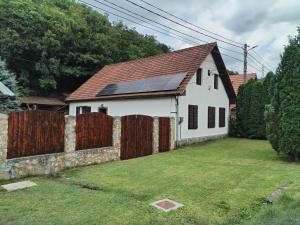 a white house with solar panels on the roof at Casa Sasca Montana in Sasca Montană