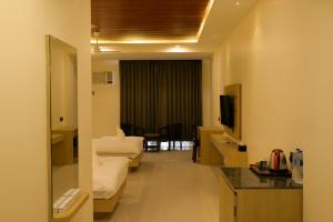 a hotel room with a couch and a television at Hotel Grand Mayfair in Dimapur