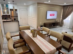 a living room with a table and a tv at Le Conviviall in Yaoundé