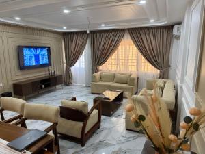 a living room with couches and a flat screen tv at Le Conviviall in Yaoundé +13 photos