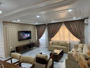 a large living room with couches and a tv at Le Conviviall in Yaoundé