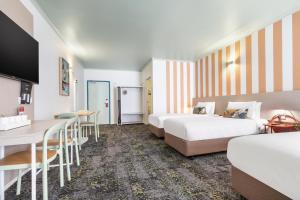 a hotel room with two beds and a table at Nightcap at the Cavenagh in Darwin +143 photos