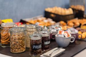 a table topped with jars of different types of nuts at Hotel Elche Centro, Affiliated by Meliá in Elche