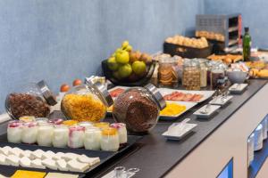 a buffet with different types of food on a table at Hotel Elche Centro, Affiliated by Meliá in Elche