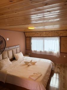 a bedroom with a bed with two towels on it at Dana luxury huts in Dana