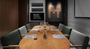 a conference room with a long wooden table and chairs at Barcelo Business Bay Dubai in Dubai +62 photos