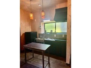 eine Küche mit grünen Schränken und einem Holztisch in der Unterkunft Cottage B&M - Vacation STAY 05964v in Usa