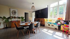 a dining room with a table and chairs and a play kitchen at Domaine Les Tourelles - Gîte 2 in Caffiers