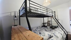 a bedroom with a bunk bed with a wooden desk at Domaine Les Tourelles - Gîte 2 in Caffiers