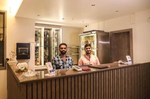 two men standing at a counter in a bar at Madhu's Palace in Amarnāth