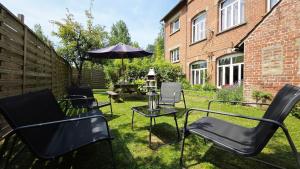 a patio with chairs and a table and an umbrella at Domaine Les Tourelles - Gîte 2 in Caffiers