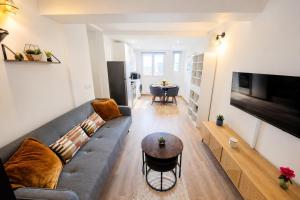a living room with a couch and a table at La Suite Prestige in Château-Thierry