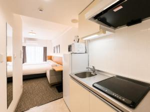 a kitchen with a sink and a room with a bed at Hotel Arashi Nippombashi 1 No006 in Osaka +54 photos
