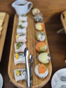 a wooden cutting board with sushi and spoons at Hilltop Kazbegi in Kazbegi