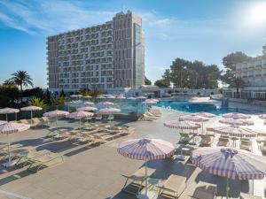 a pool with chairs and umbrellas and a building at SOL by Meliá Barbados in Magaluf